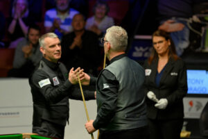Mark Davis and Tony Drago embrace at the 2023 World Seniors Snooker Championship.