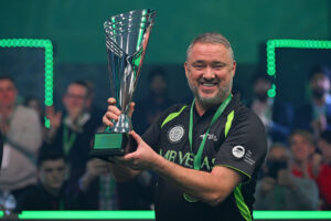 A smiling Stephen Hendry wears his medal and lifts the trophy.