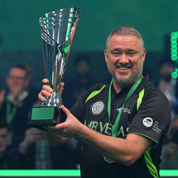 A smiling Stephen Hendry wears his medal and lifts the trophy.
